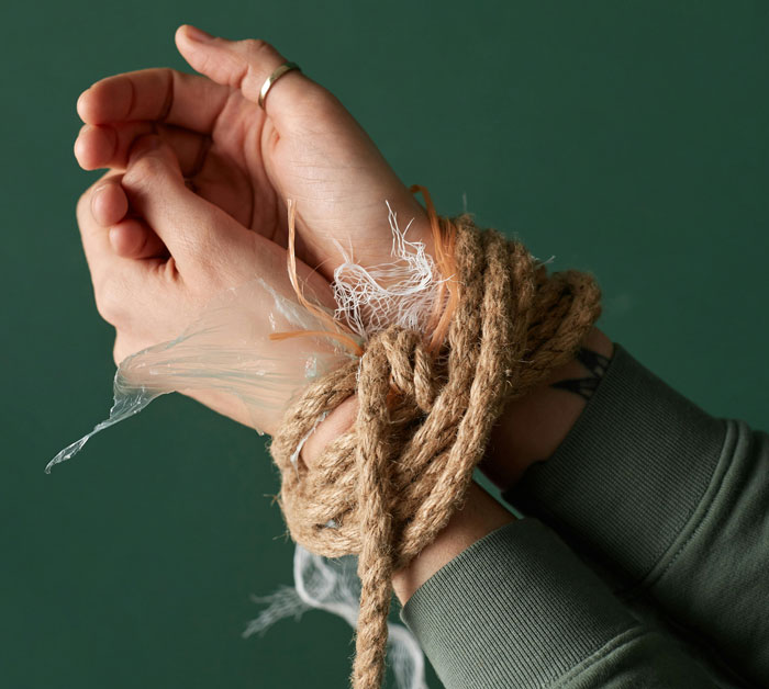 Hands tied with rope, illustrating life-saving escape techniques in potential emergency situations.