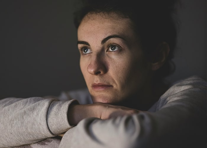 Woman deep in thought, contemplating parenting mistakes and challenges.