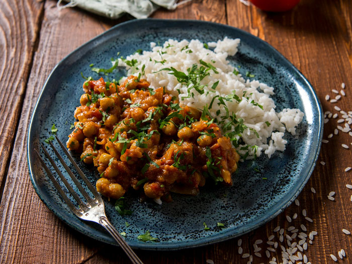 Lazy meal: chickpeas in tomato sauce with rice on a blue plate.