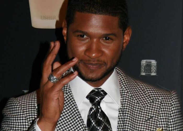 Man in a checkered suit and patterned tie, gesturing with his hand, associated with amazing dad stories.
