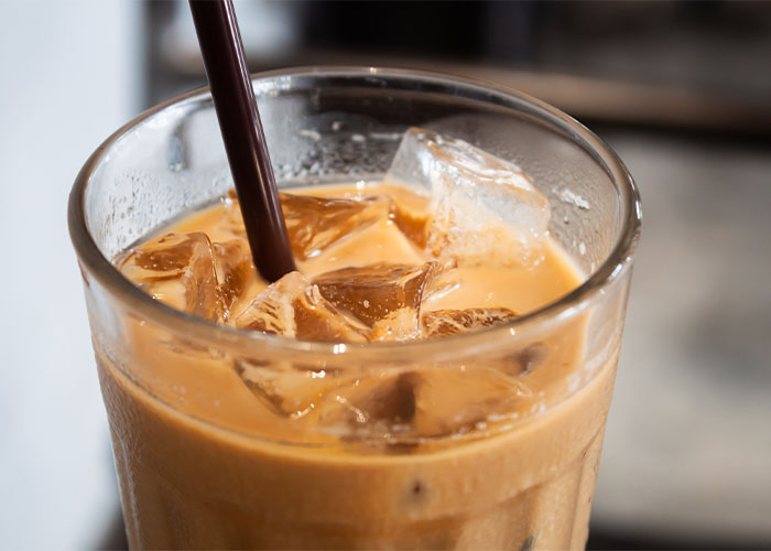 Iced coffee in a glass with a straw, capturing a once exotic beverage enjoyed worldwide.