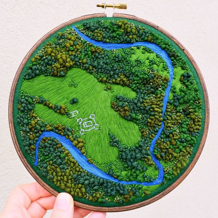Landscape embroidery with rivers and greenery, showcasing intricate handwork by Victoria Rose Richards.
