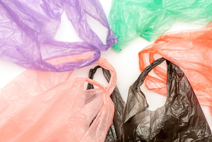 Colorful plastic bags on a white surface, showcasing old people's habits of reusing common items.