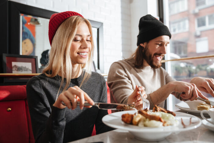 Two people in a cozy cafe enjoying a meal, embracing simple, old-fashioned habits.