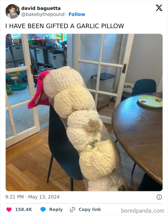 Knitted garlic pillow with pink bow on chair in a cozy room, showcasing relatable middle class fancy humor.
