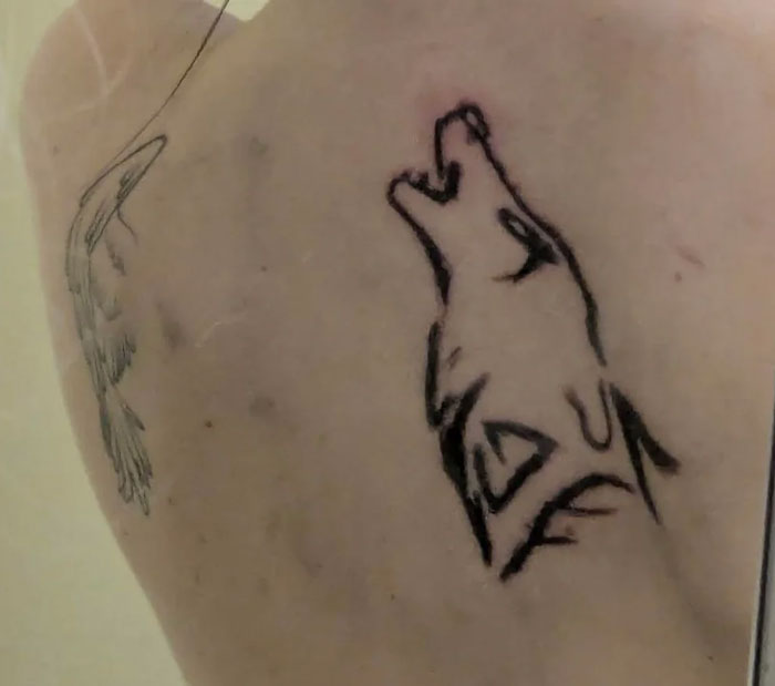 Wolf tattoo on a person's back, illustrating unattractive tattoo designs.