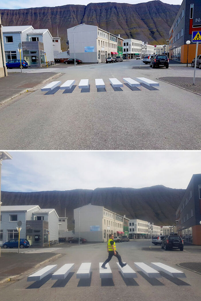 3D street art illusion of a floating crosswalk on a city street with mountains in the background.