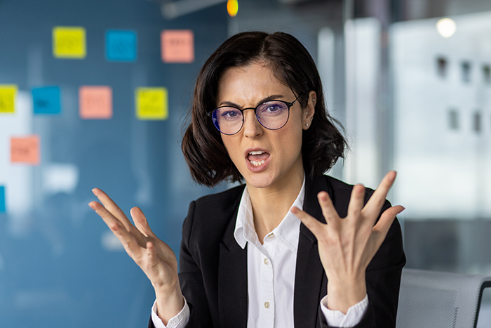 Manager in business attire at a bank, expressing frustration during a meeting.