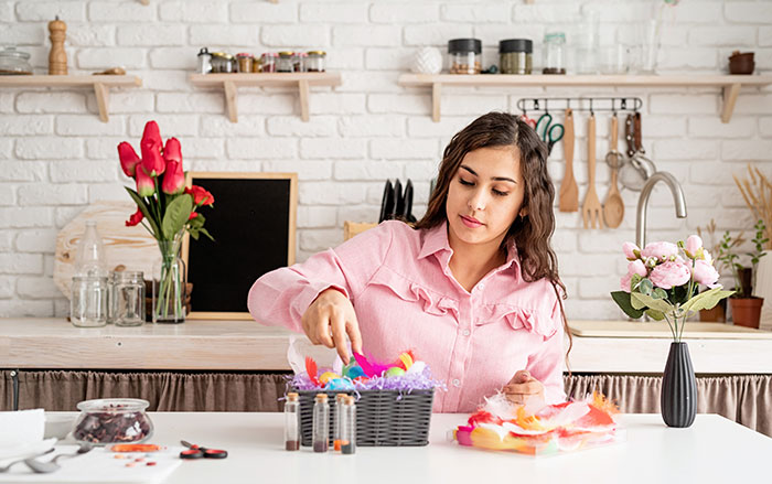 Woman decorates kitchen with vibrant materials, flowers. Woman decorates kitchen with vibrant materials, flowers.