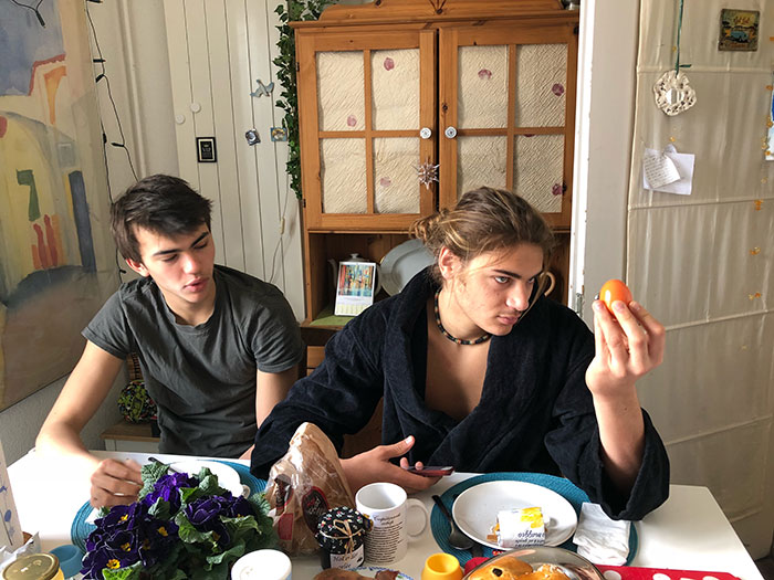 Roommates at a table with sparse food, highlighting food-related conflict. Roommates at a table with sparse food, highlighting food-related conflict.