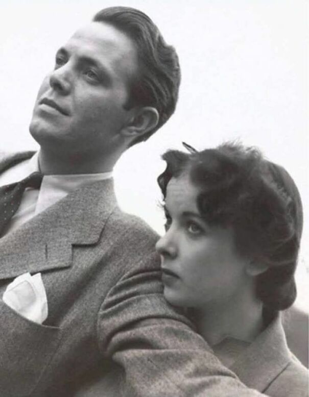 A vintage black-and-white photo of a couple wearing suits, embodying historical fashion and style.
