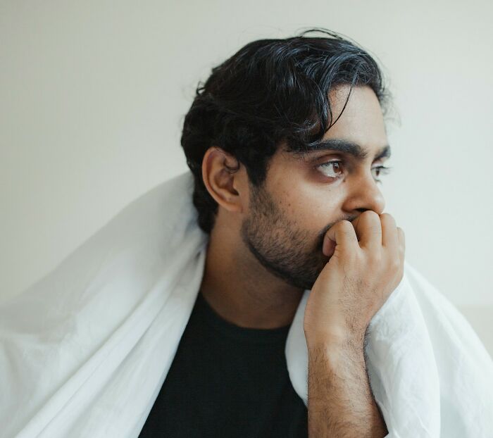 Person looking concerned with hand on chin, highlighting sudden dizziness awareness.