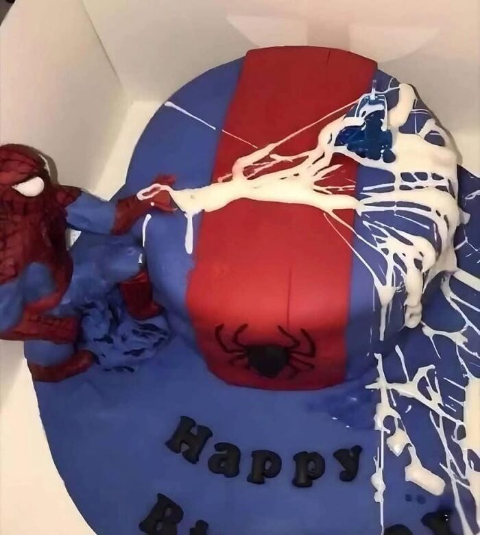 Spider-themed cake with baking fails, showing a figure and smeared icing in blue and red colors.
