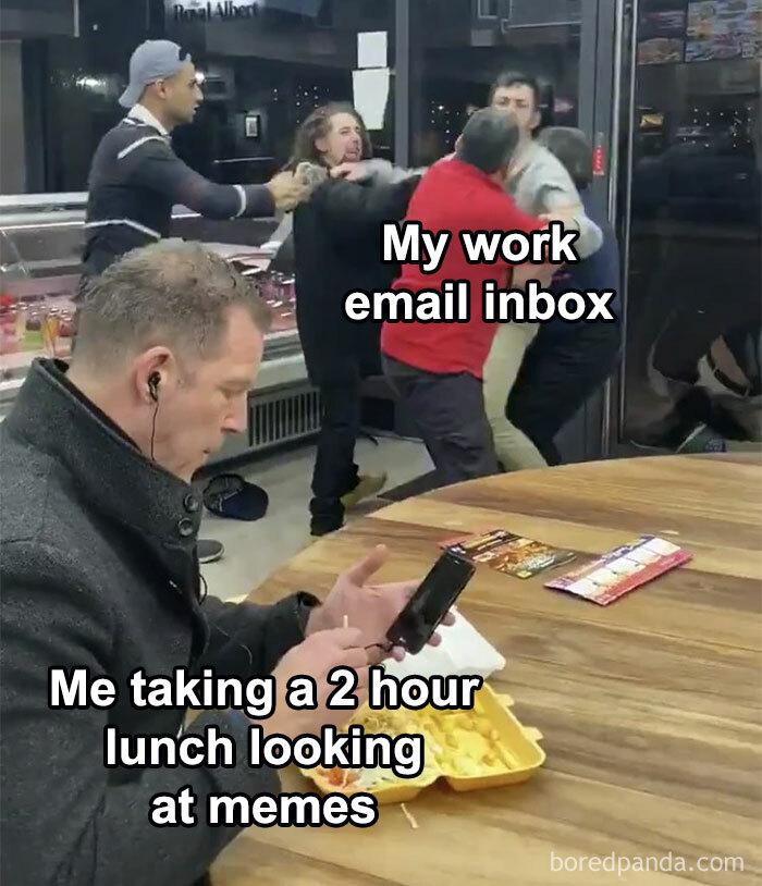 Man on phone during lunch break while chaos erupts behind, illustrating a relatable job meme.