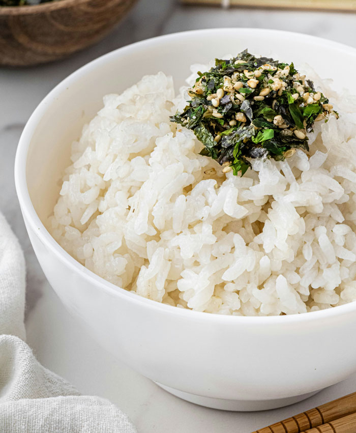 Bowl of rice topped with herbs and seeds, showcasing one of the best lazy meals shared online.