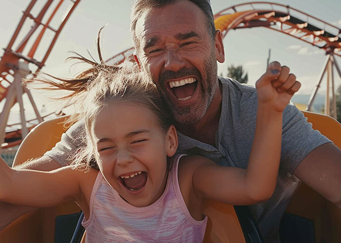 Father and daughter happily riding a roller coaster, capturing a memorable dad moment.
