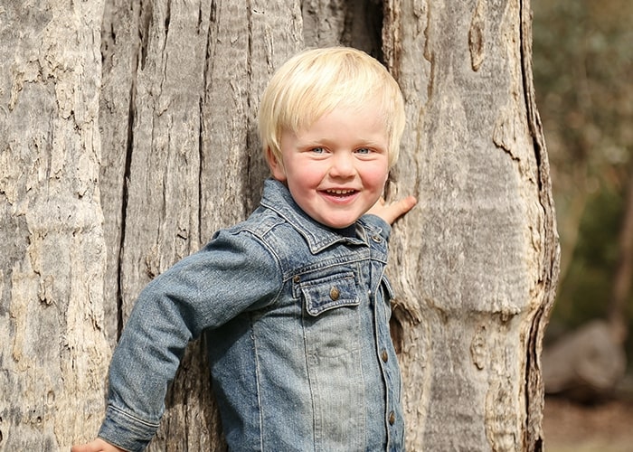 Child smiling in a denim jacket, highlighting parenting mistakes importance.