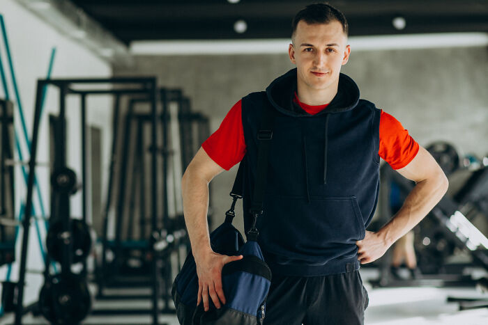 Man in gym holding a sports bag, showcasing life after earning a "useless" degree.