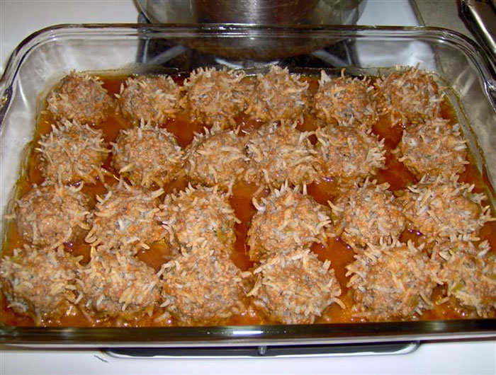Old-school delicacies in a baking dish, featuring meatballs covered with shredded coconut, capturing a nostalgic recipe.