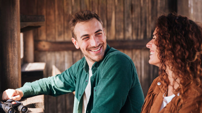 Two people smiling at each other, suggesting positive first date green flags.
