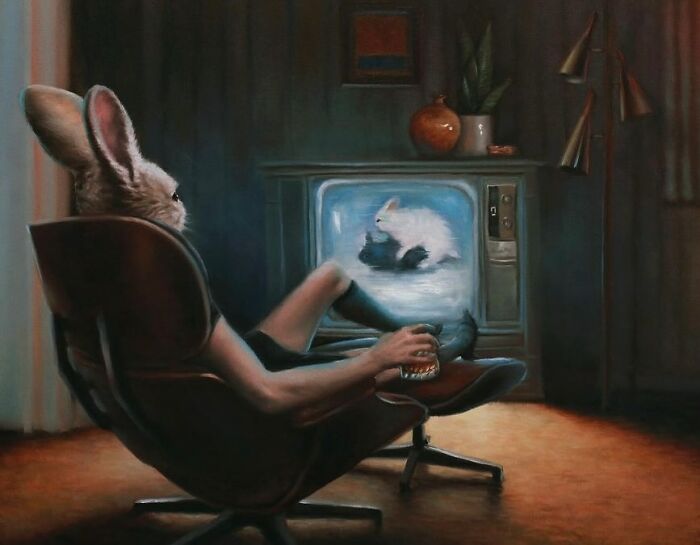 Rabbit in armchair watching TV, holding a drink, showcasing anthropomorphic artwork by Richard Ahnert.