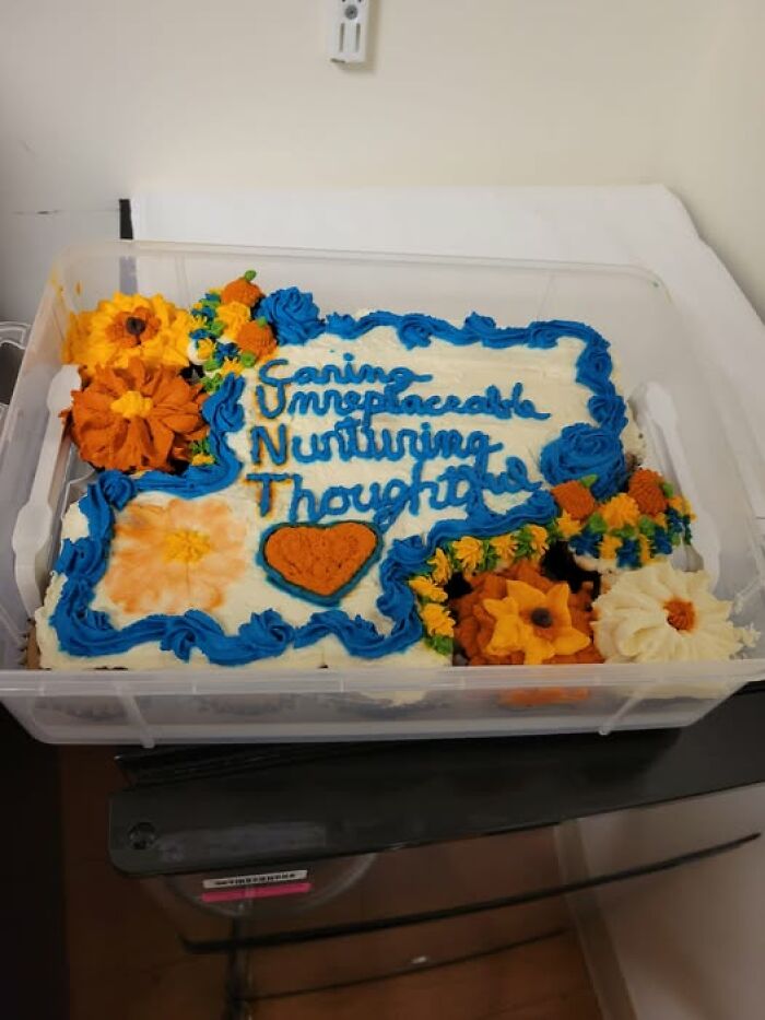 Decorative cake topped with blue icing text and orange flowers, showcasing funny baking fails.