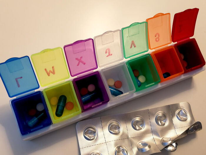 Pill organizer with colorful compartments, reflecting an appreciated "old people" habit.