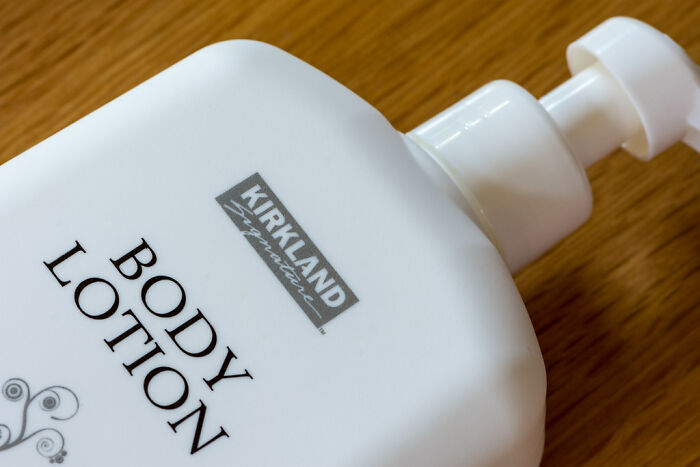 Kirkland Signature body lotion bottle on a wooden surface, representing a cheap version that outperforms expensive brands.