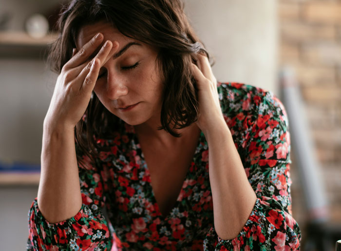 Woman in a floral dress, stressed, considering her husband's demands to drive him to work. Woman in a floral dress, stressed, considering her husband's demands to drive him to work.