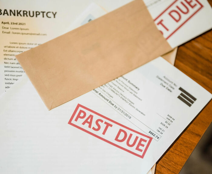 Past due bills on table with "Bankruptcy" document related to genetics company.
