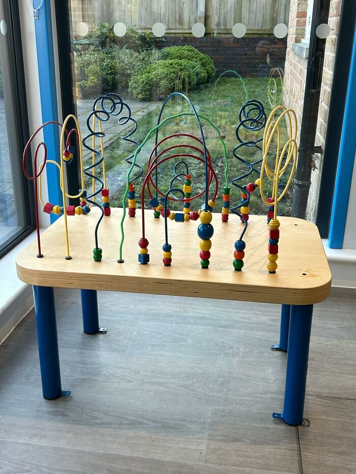 Bead maze toy on a wooden table, illustrating a quintessentially British childhood play scenario.