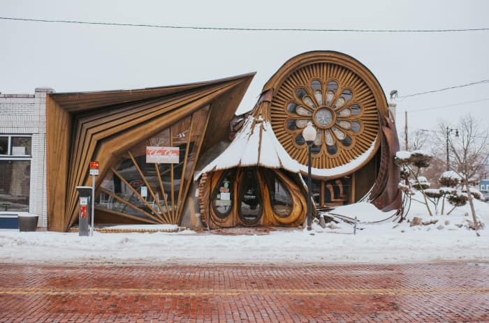 Edificio con diseño arquitectónico inusual cubierto de nieve en invierno.