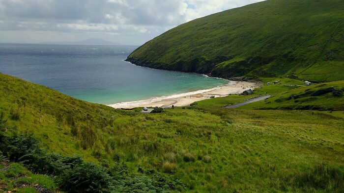 Stunning beach with clear blue water and lush green hills, ideal for a dream vacation.