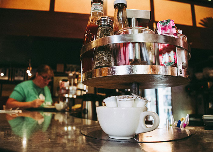 Condiment carousel on a diner counter, evoking life without social media nostalgia with a vintage atmosphere.