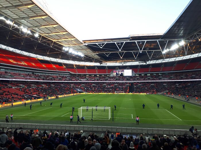 Soccer stadium filled with fans, players warming up on the pitch inside one of the cathedrals of soccer legends born.