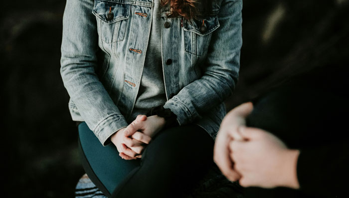 Couple in discussion, one wearing a jean jacket, focusing on relationship dynamics.