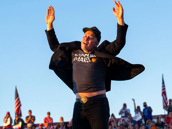 Man raising arms enthusiastically at outdoor event, highlighting overlooked problems affecting mental health.