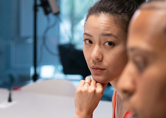 Woman in office setting, looking concerned, highlighting toxic workplace dynamics.