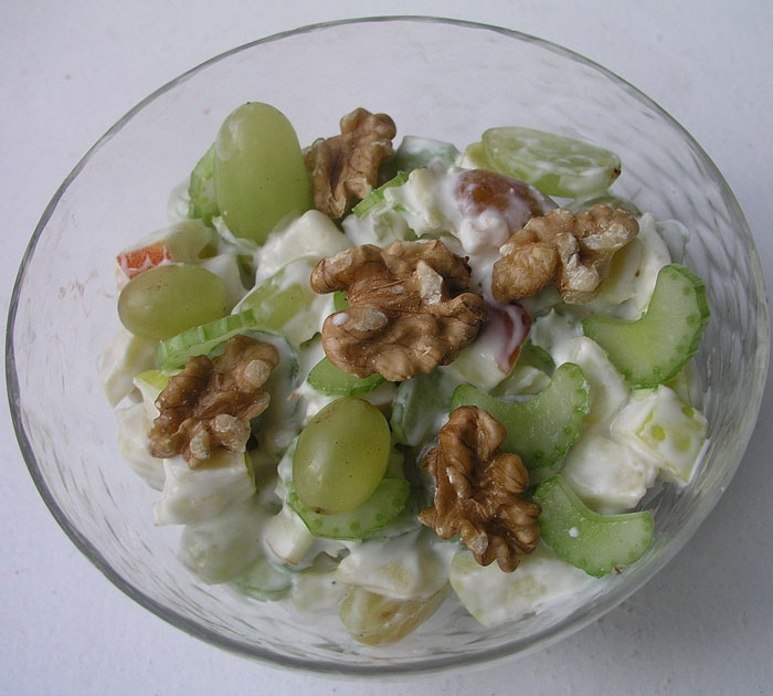 Bowl of Watergate Salad with grapes, walnuts, and creamy dressing in a glass dish.