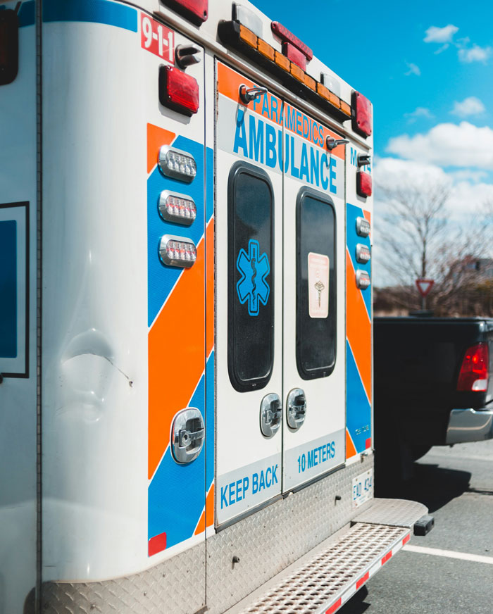 Ambulance with emergency symbols parked under a clear sky. Life-saving vehicle with emergency lights visible.