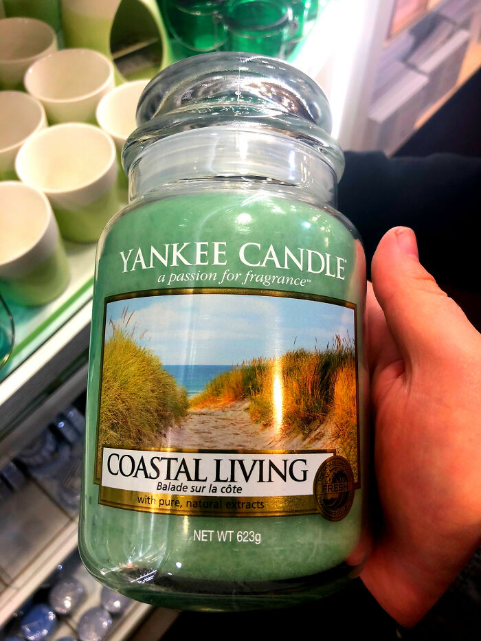 Green Yankee Candle labeled "Coastal Living" held in a hand, related to weirdest things removed from bodies.