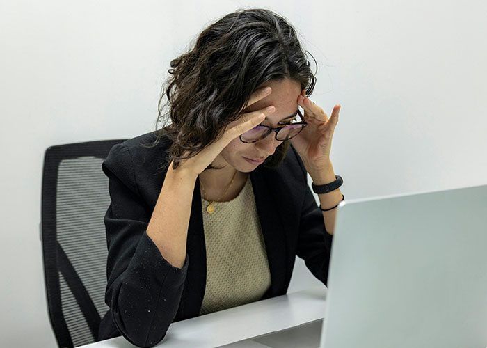Person at desk, stressed, highlighting toxic workplace signs.