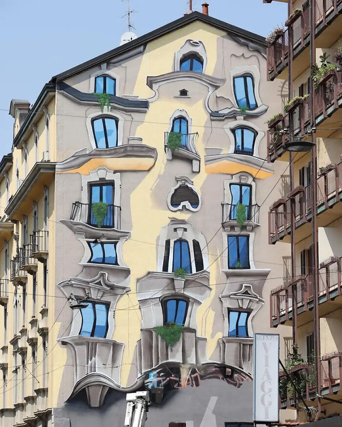 3D street art masterpiece on a building facade, creating a mind-bending optical illusion with warped windows and balconies.