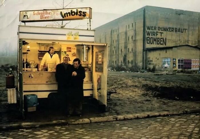 A historical food stand in an urban setting, with patrons enjoying snacks, showcasing forgotten corners of history.