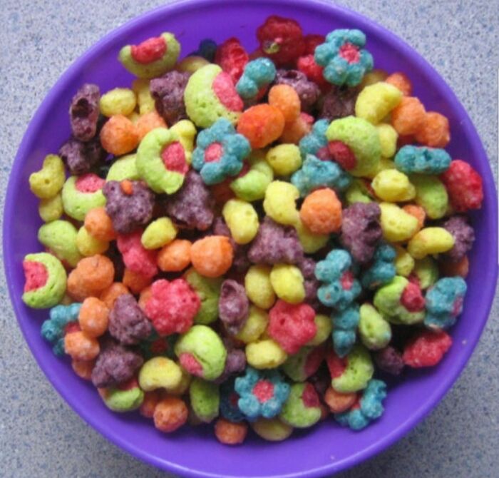 Colorful discontinued cereal pieces in a purple bowl, evoking nostalgia and memories of past products.
