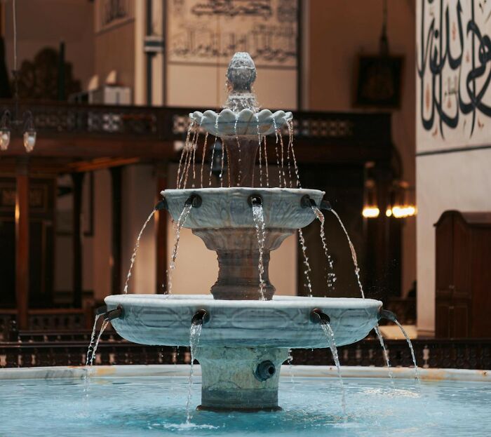 Beautiful, cascading wedding fountain with flowing water in an ornate indoor setting.