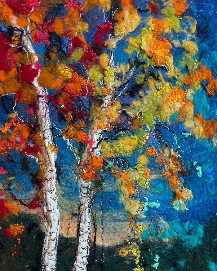 Fiber art depicting a vibrant, colorful tree landscape, showcasing scenery artwork created with fibers instead of paint.