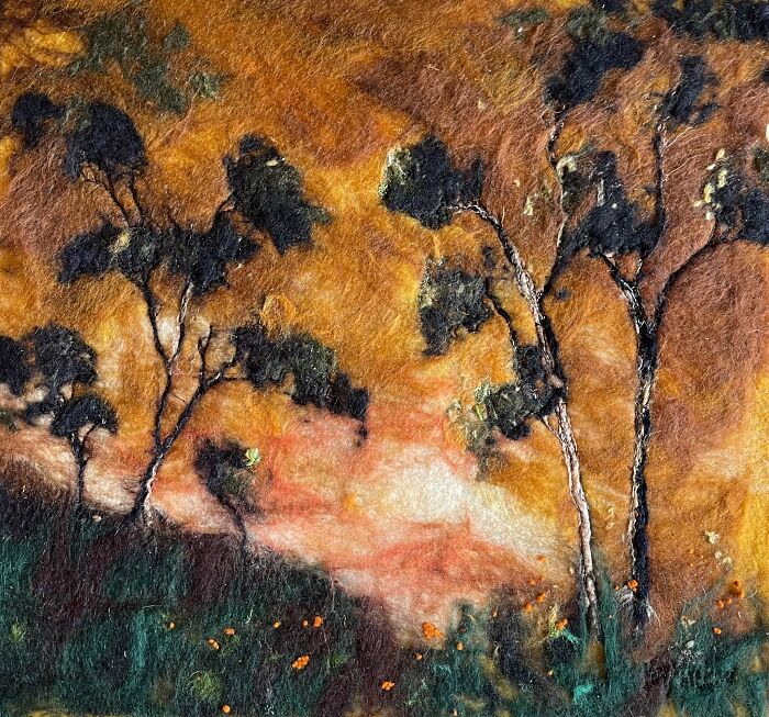 Fiber art depicting a beautiful scenic landscape with trees against a vibrant, textured backdrop.