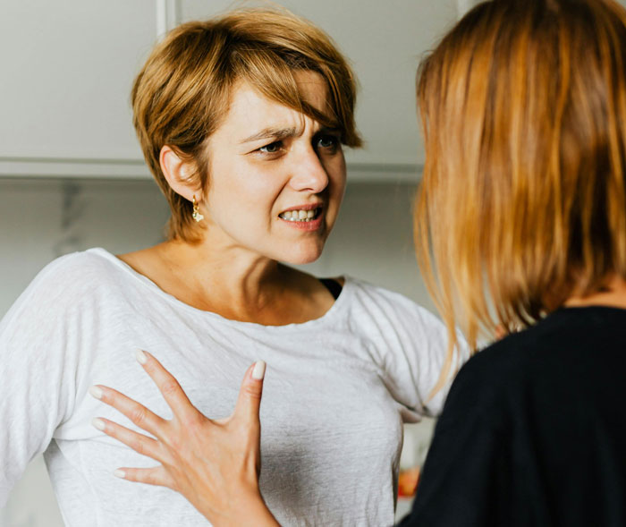 Woman arguing intensely with another woman, embodying a harsh reality check after a babysitting disagreement.