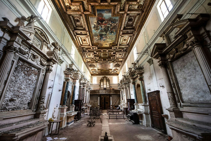 Abandoned place with ornate ceiling and decaying walls, showcasing beauty enhanced over time.